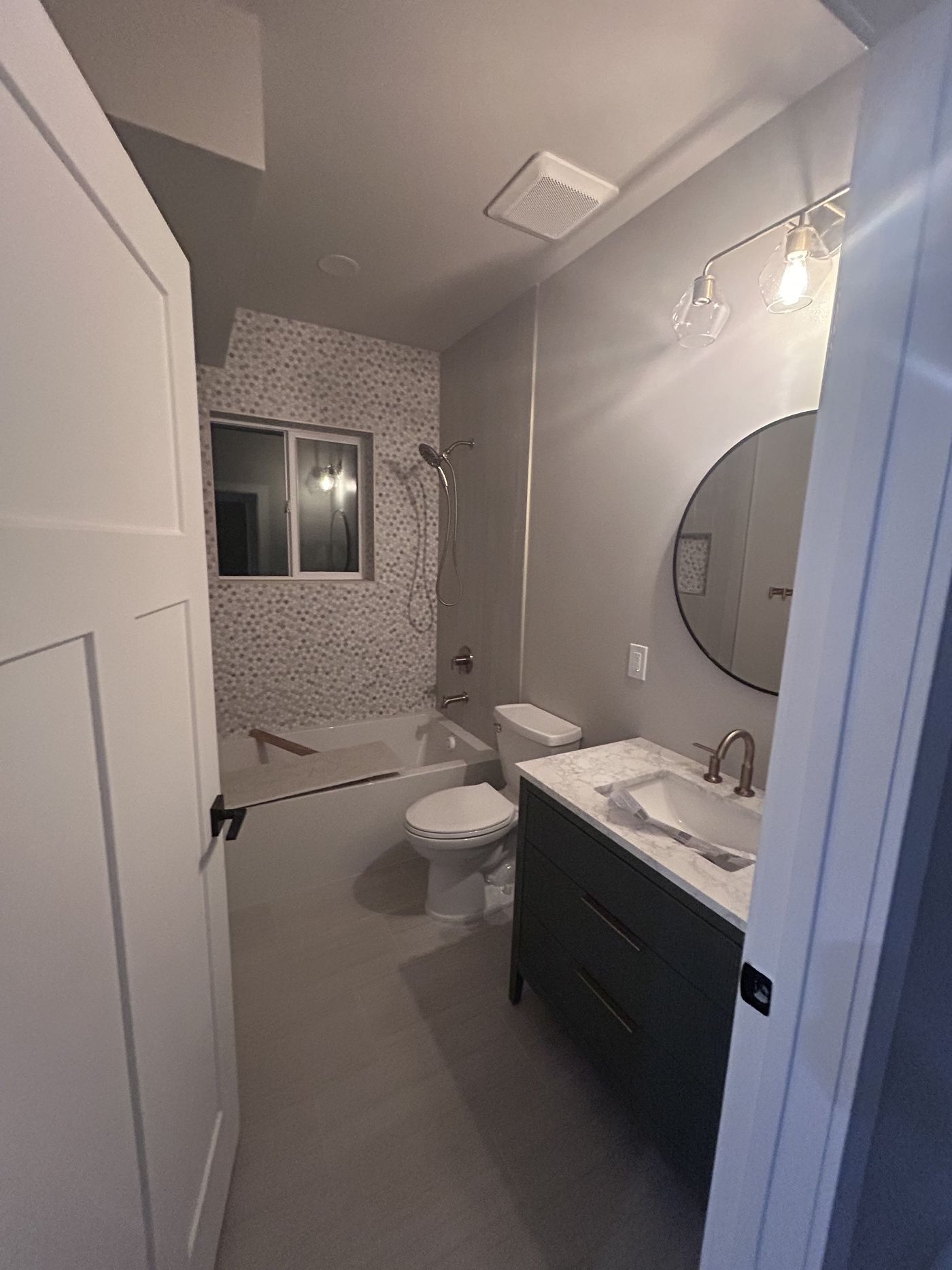 Example finished bathroom with tile surround and stone countertop, illustrating typical finish quality